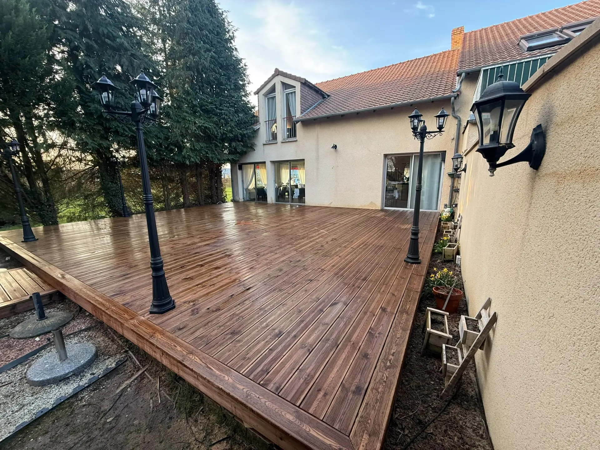 Grande terrasse en bois réalisée autour d'une maison