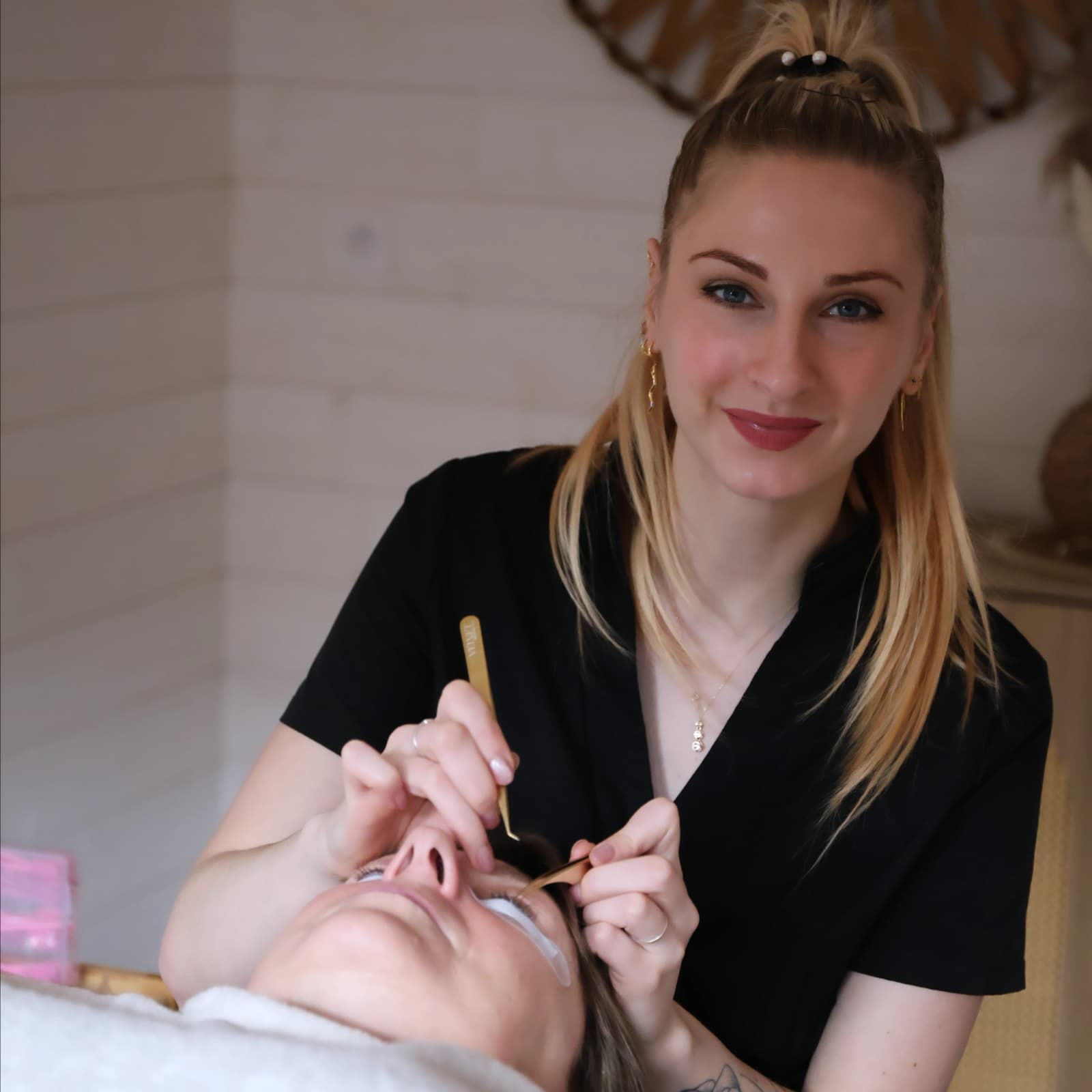 Claire, esthéticienne, réalisant une pose d’extensions de cils dans son institut