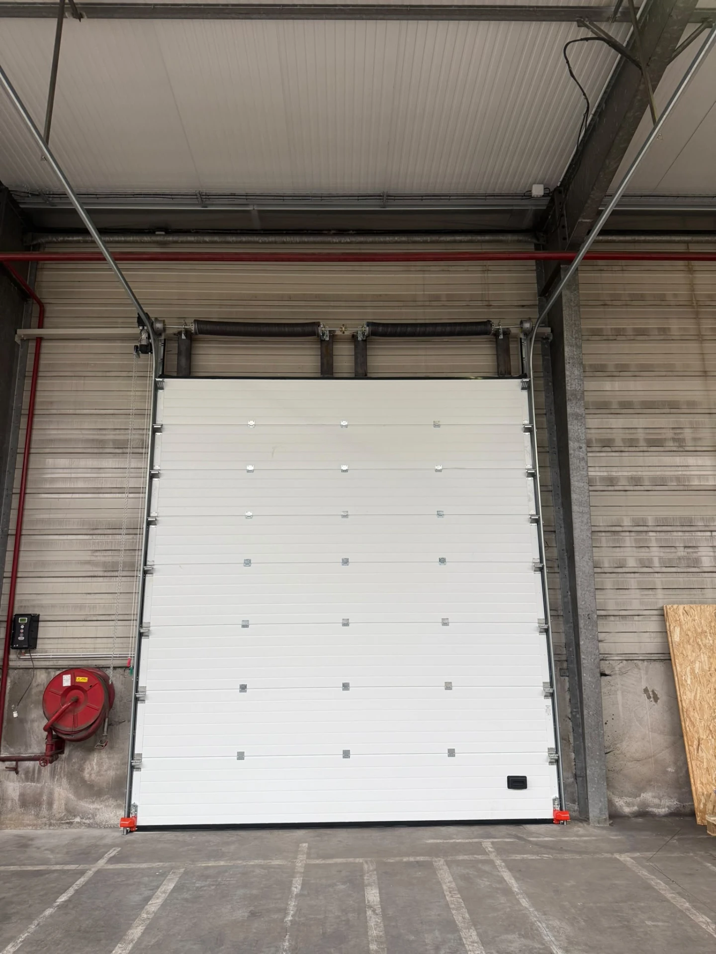Porte sectionnelle blanche installée dans un bâtiment professionnel