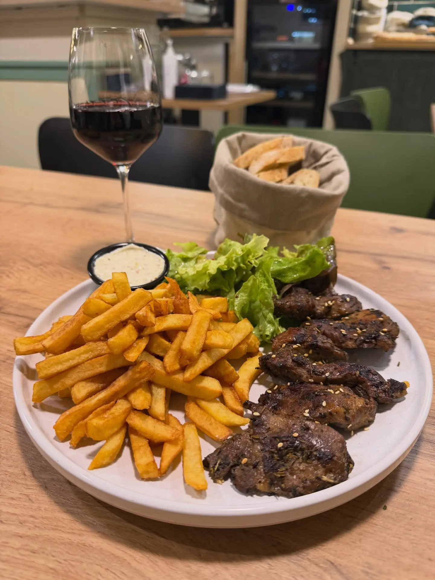 Assiette de grillades avec frites maison et verre de vin rouge